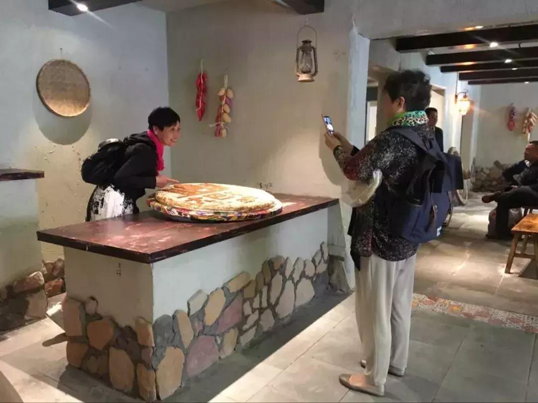 游客用手拿馕合影后放回去被怒斥游客不当行为引发争议，手拿馕合影后被怒斥